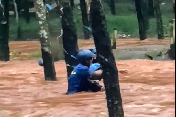 2 nguoi dan ong mac ket giua dong nuoc xiet hinh anh