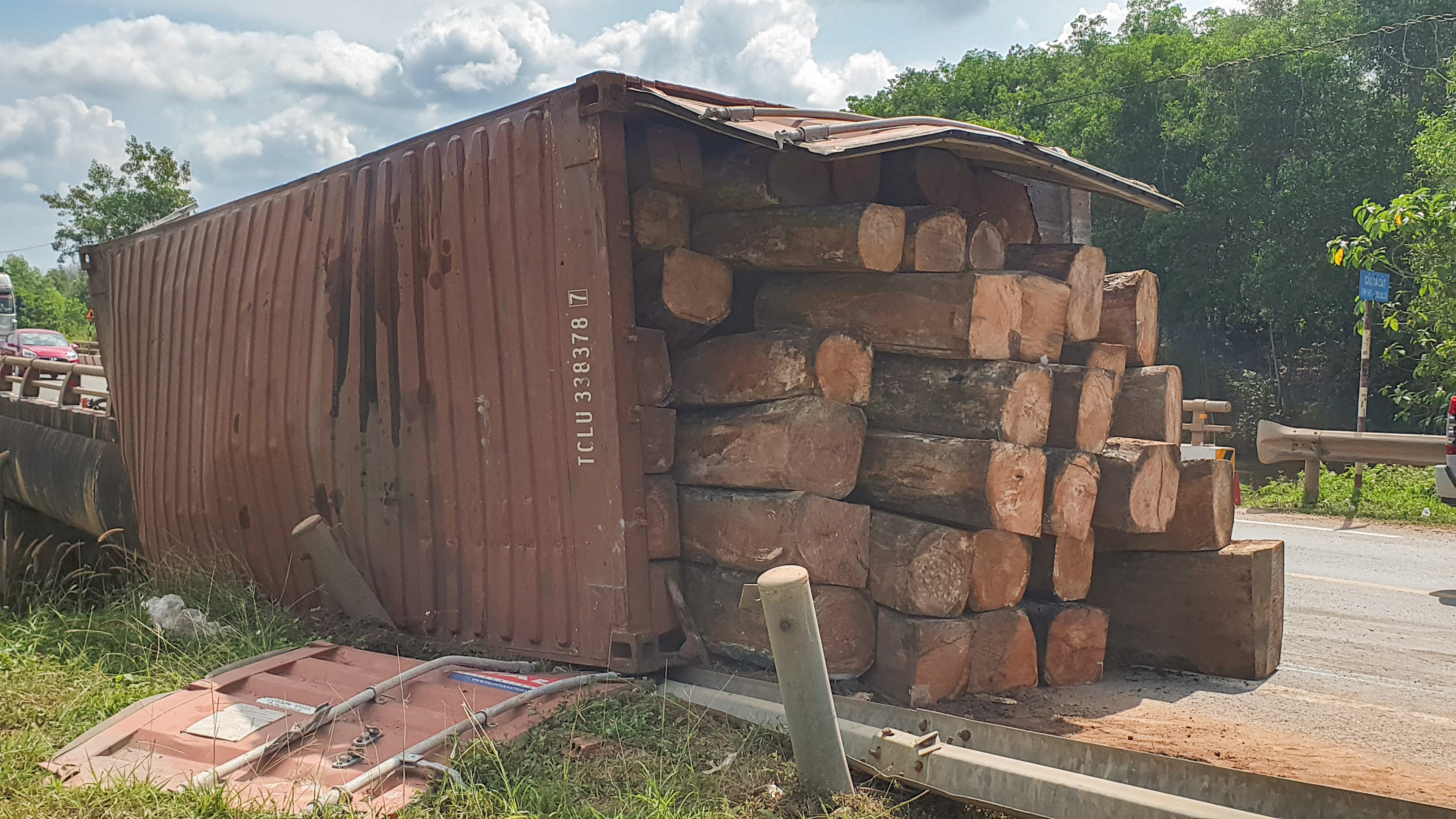 Xe container cho go do doc lat xuong cau, 4 nguoi bi thuong hinh anh