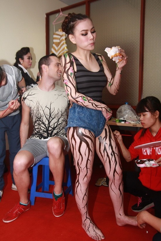 Nguyên Vũ cũng chỉ có thể ăn bánh mì trong khi vừa được trợ lí chuẩn bị trang phục.