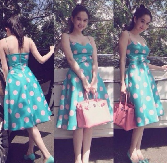 Ngọc Trinh tôn làn da trắng sứ với váy xanh chấm bi và túi hồng.