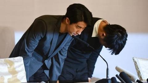 Phùng Tổ Minh (trái) cúi đầu xin lỗi công chúng tại cuộc họp báo được tổ chức sau khi anh ra tù.