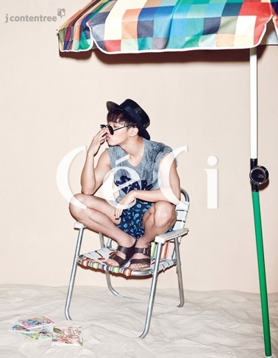 Cũng với áo thun và quần short, Gi Kwang phối cùng sandals, kính gọng tròn và mũ fedora khiến set đồ trở nên nổi bật.