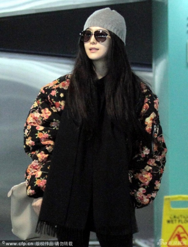 Áo khoác to sụ khiến cô như cuốn chăn bông quanh người.