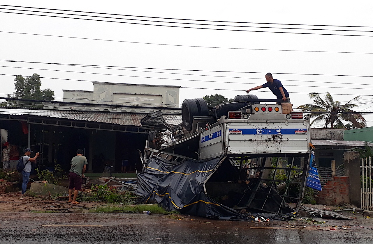 Xe tải ủi bay hàng rào, lật chổng vó trước sân nhà dân ảnh 1 Xe tai ui bay hang rao, lat chong vo truoc san nha dan anh 1