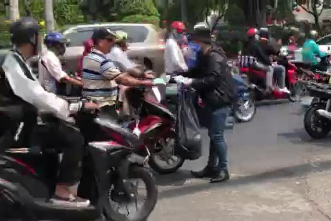 Clip nam thanh nien phat khau trang cho nguoi di duong hinh anh