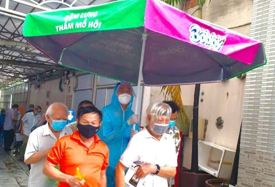 Chang trai che mua cho nguoi lon tuoi o diem tiem vaccine tai TP.HCM hinh anh