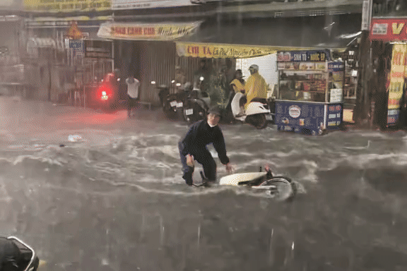 Nguoi di xe may te nga trong mua lon o TP.HCM duoc giup do hinh anh