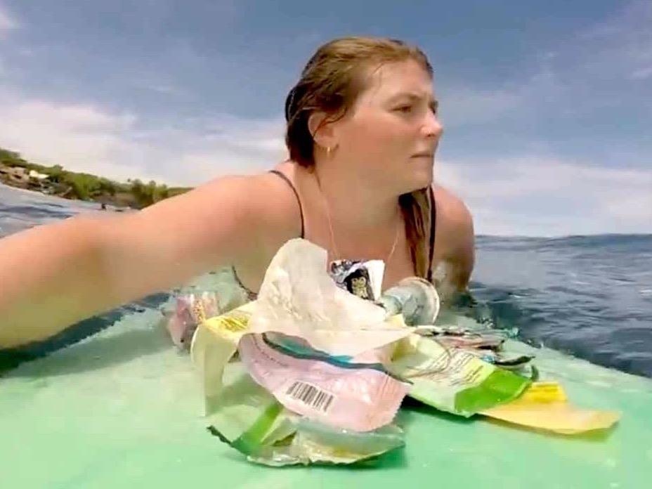 Nu du khach luot van thu gom rac thai nhua tren bien Bali hinh anh