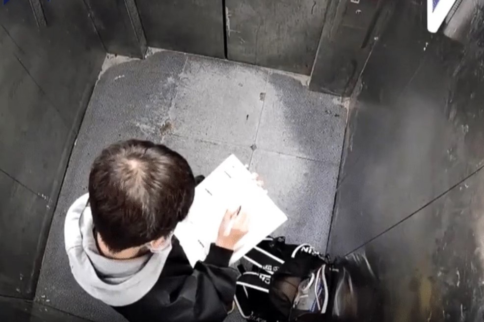 Be trai lam bai tap khi bi mac ket trong thang may o Trung Quoc hinh anh