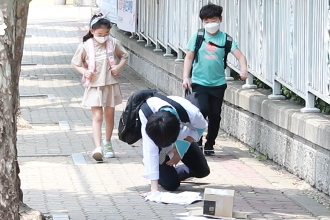 Hoc sinh tieu hoc Han Quoc lam gi khi thay nguoi la nga tren duong? hinh anh