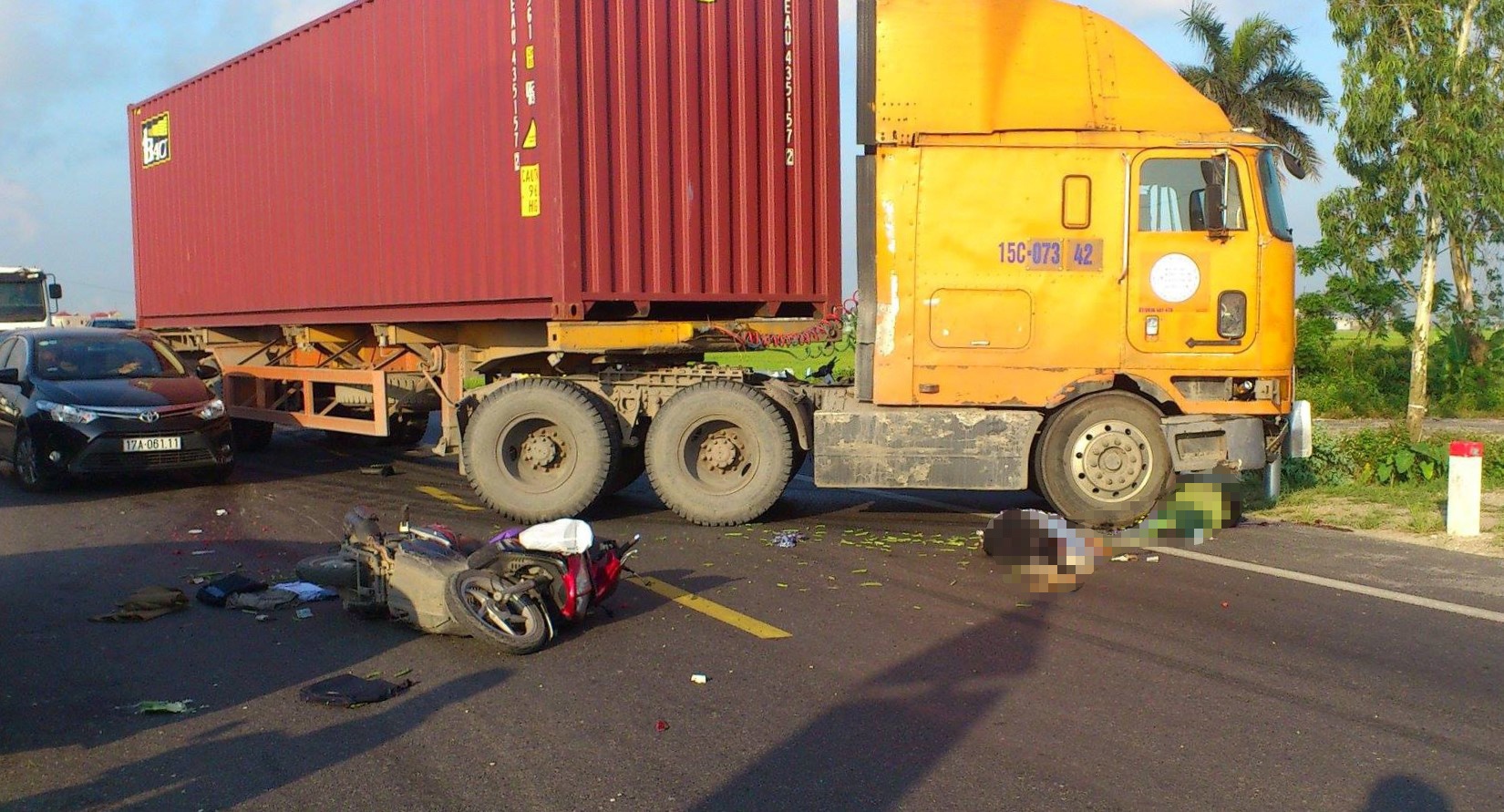 Va cham voi oto dau keo container, 2 vo chong di xe may tu vong hinh anh
