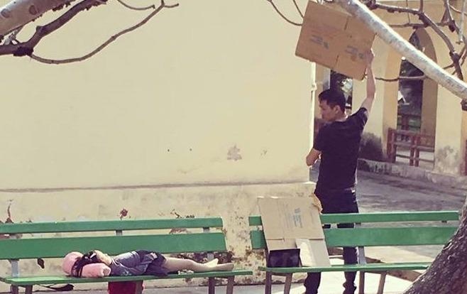 Nguoi cha loay hoay che nang cho con gai ngu tren ghe hinh anh