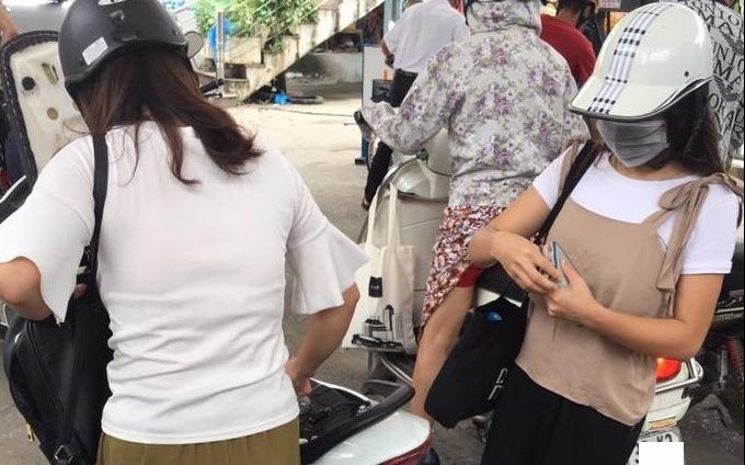 Hai co gai gay buc xuc khi chen hang do xang voi nguoi lon tuoi hinh anh