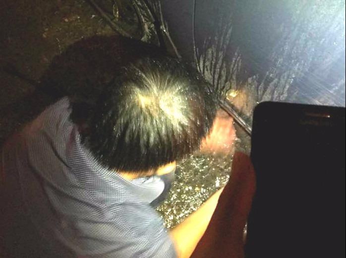 Chang trai cam o che cho bac tai xe thay lop oto giua con mua lon hinh anh