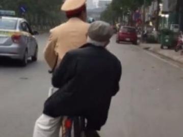 Chien si CSGT di xe dap cho cu ong bi lac duong ve nha hinh anh