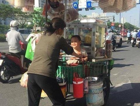 Em be Sai Gon mim cuoi hanh phuc ben ganh hang rong cua me hinh anh