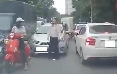 Nu du khach ngoai quoc chan oto di lan lan, giup cac xe de di chuyen hinh anh
