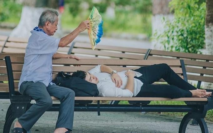 Ong quat cho chau ngu tren ghe da trong ngay nhap hoc hinh anh