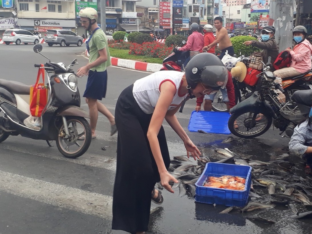 Hai nguoi nuoc ngoai giup xe may cho ca bi do giua duong hinh anh