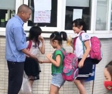 Bac bao ve dap tay, chao hoi hoc sinh truoc cong truong moi sang hinh anh