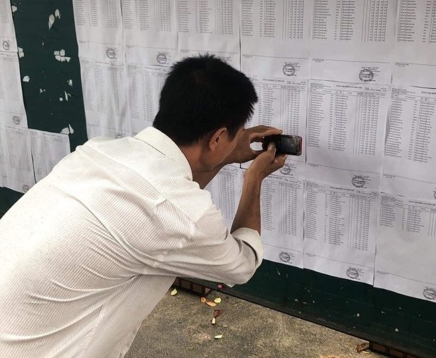 Cha ngheo dung dien thoai cu chup lai ket qua thi cho con gai hinh anh