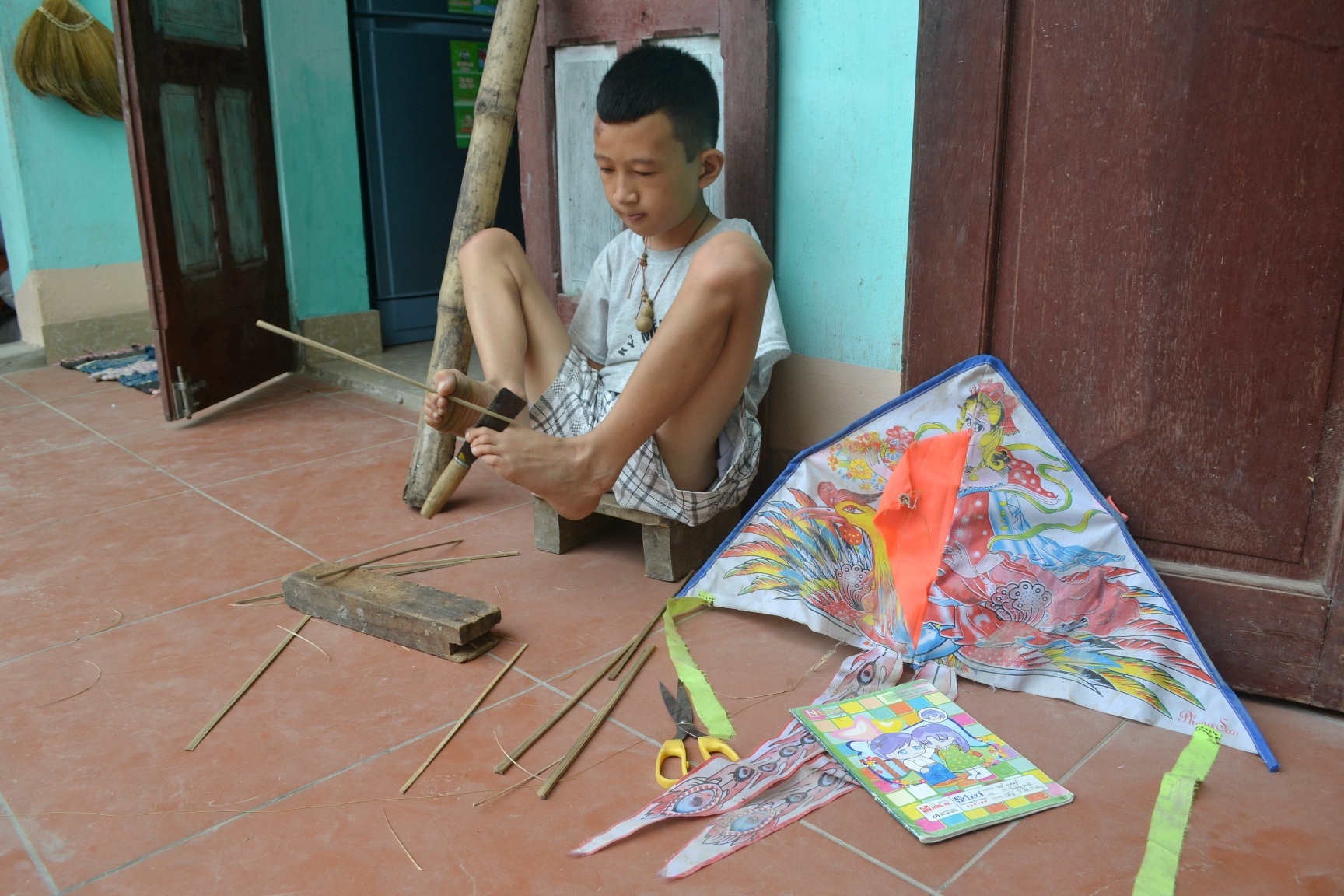 Em còn có thể bắn bi bằng chân, đá bóng, thả diều. Những hôm diều hỏng, em tự mình chẻ tre để sửa.