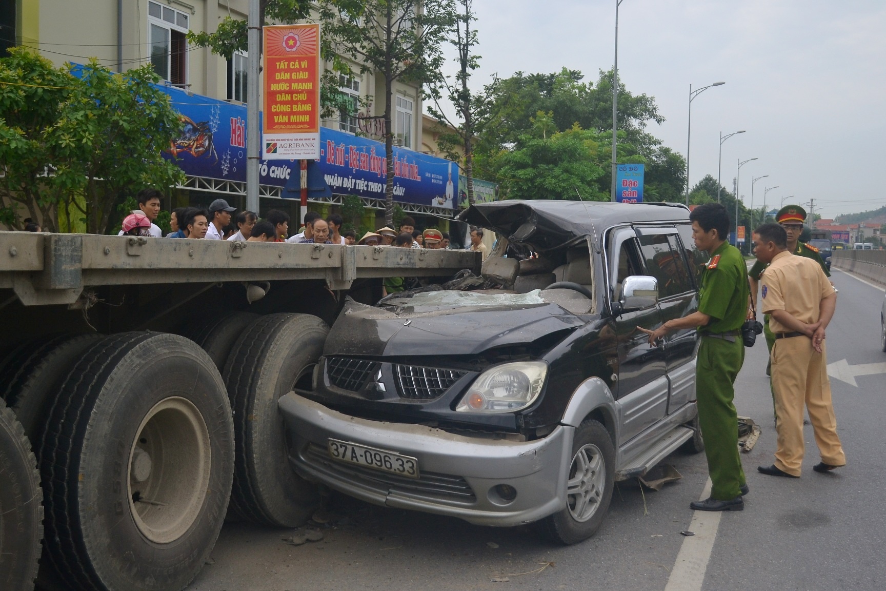 Cú tông cực mạnh làm ôtô 7 chỗ dính chặt vào đuôi xe container.