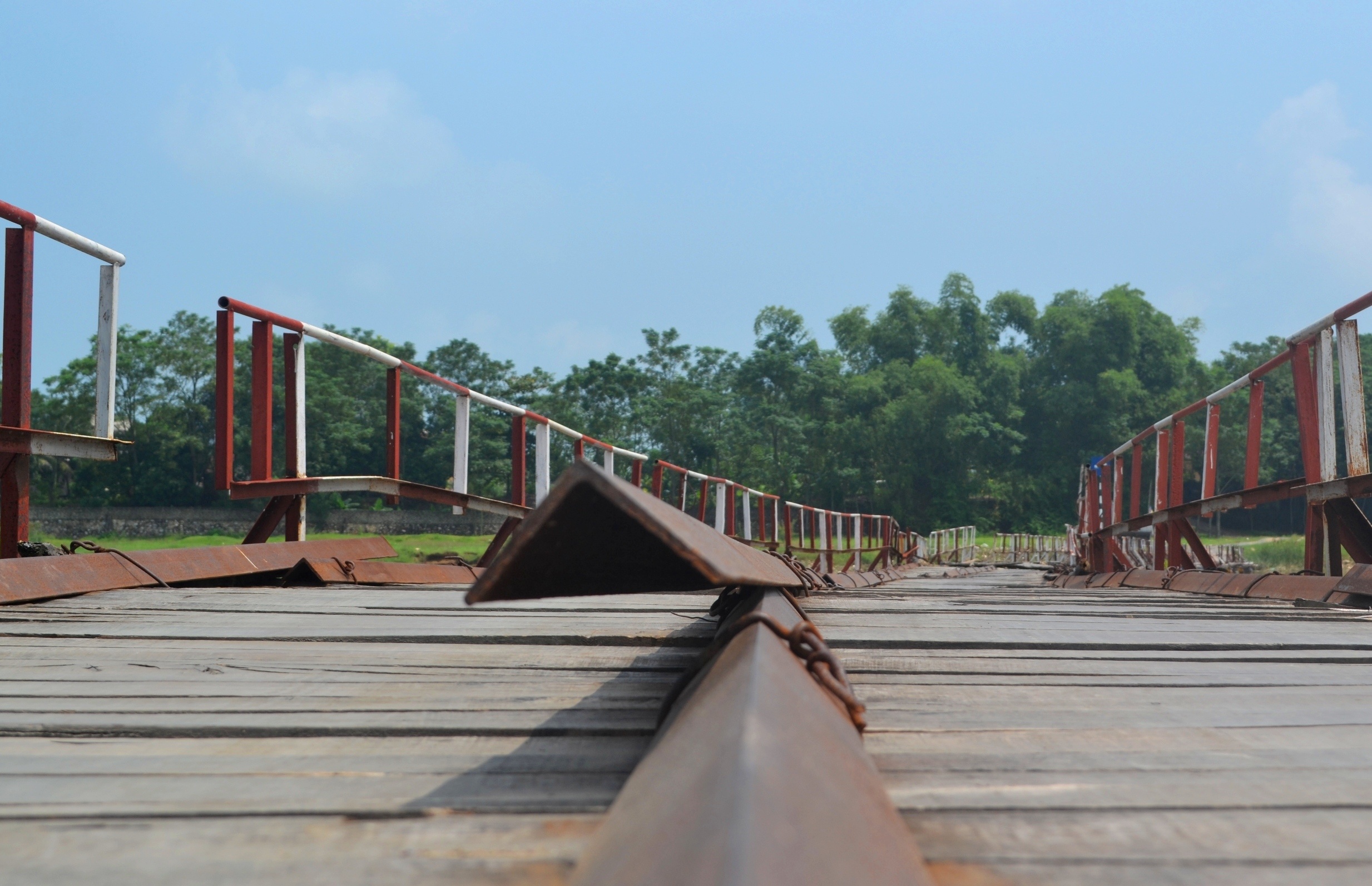 Thanh thép ở giữa cầu để chằng, kết nối các tấm gỗ bị bung hẳn trên mặt đường trở thành cái “bẫy” khiến người đi qua dễ dàng bị vấp ngã.