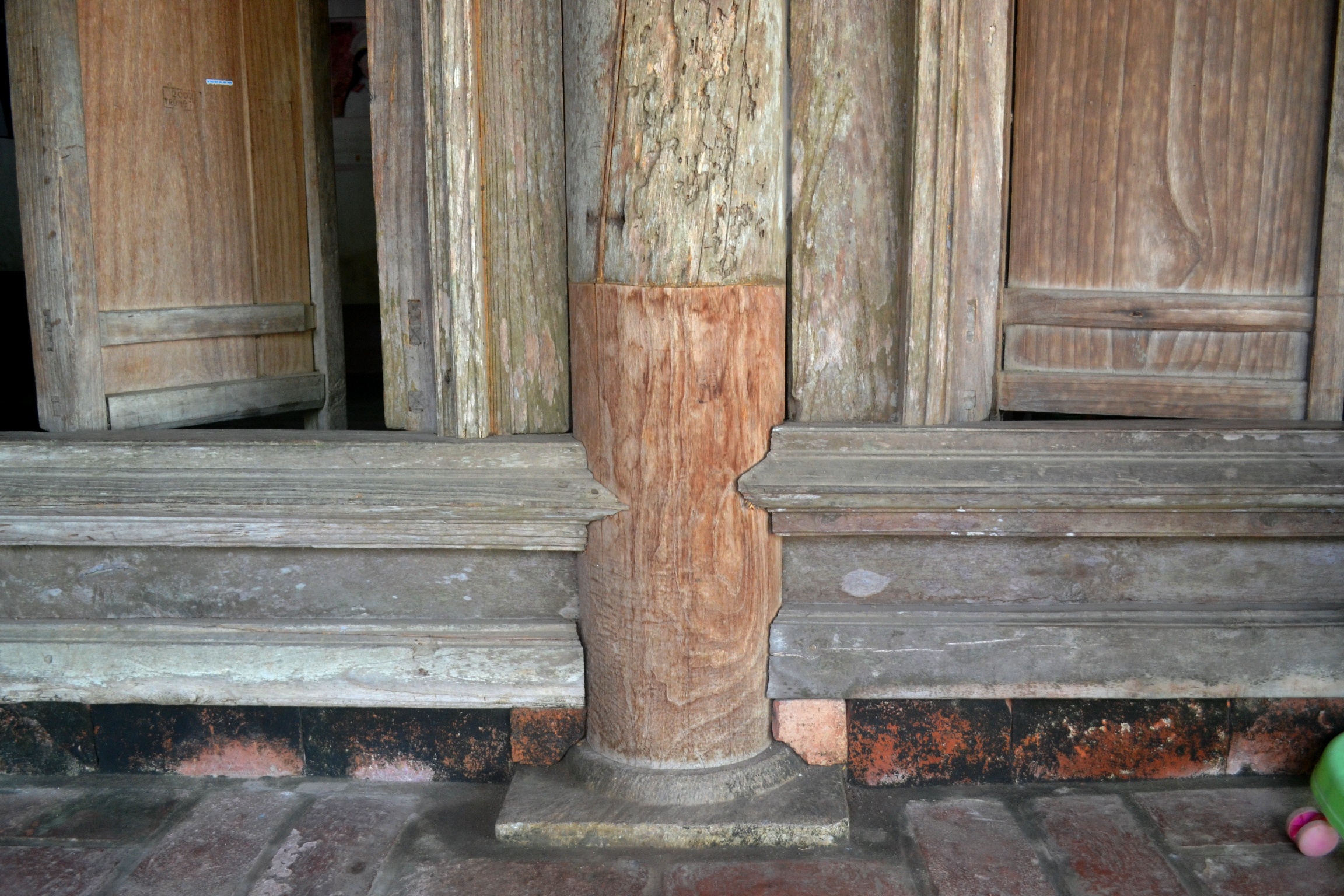 Những cây cột gỗ chống đỡ bộ mái ngói đất nung. Chân cột đặt trên đế bằng đá tảng mang dấu tích nhà từ đường của người Việt ở nông thôn. 