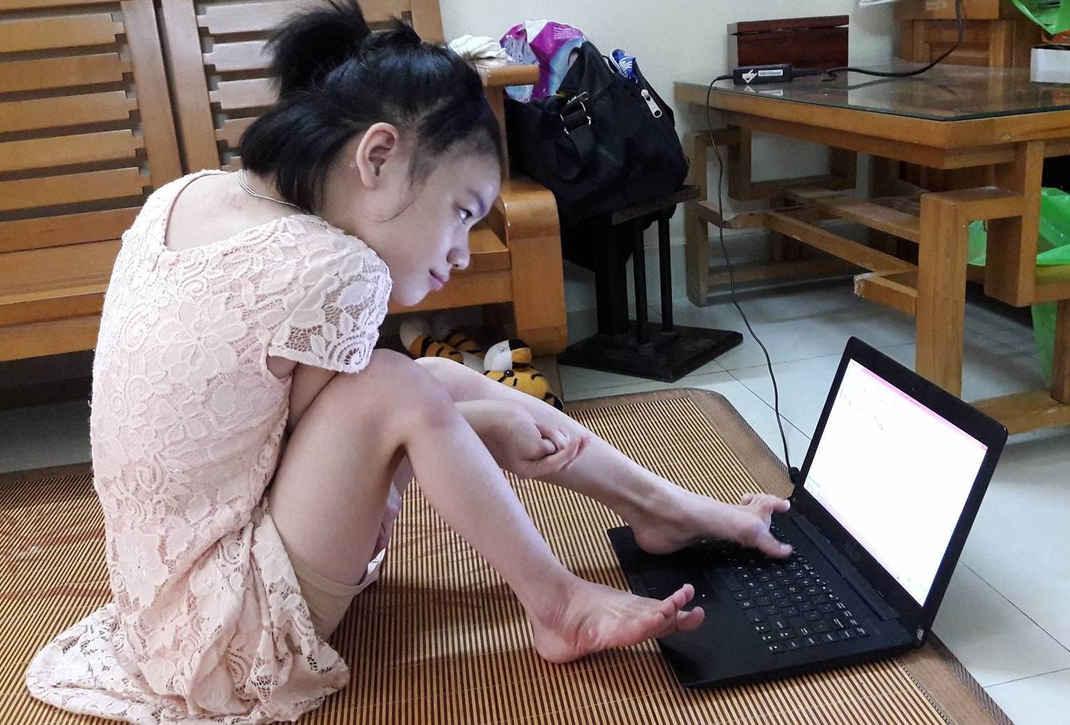 Nghi luc cua nu sinh go may tinh bang mot chan hinh anh