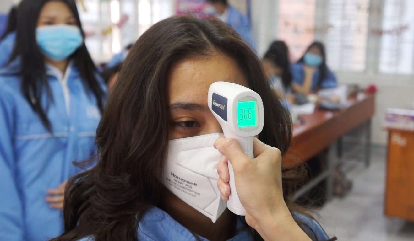 Hoc sinh xep hang kiem tra suc khoe khi den truong hinh anh