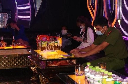 Nu tiep vien quan karaoke van tiep khach giua mua dich hinh anh