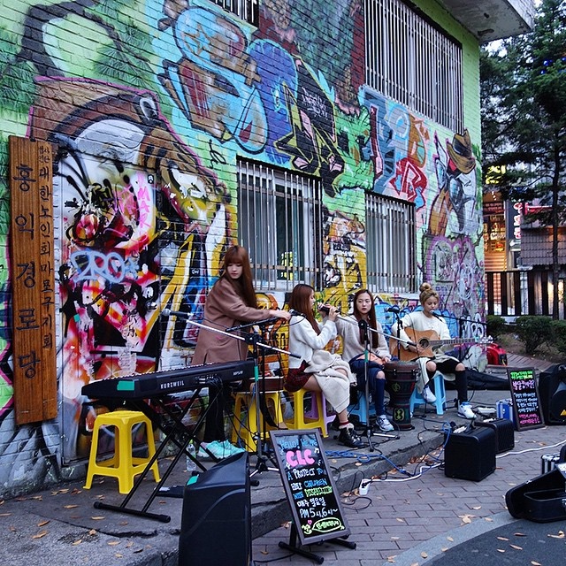 Nhóm CLC vừa hát vừa chơi nhạc cụ trên phố trong thời tiết giá lạnh.