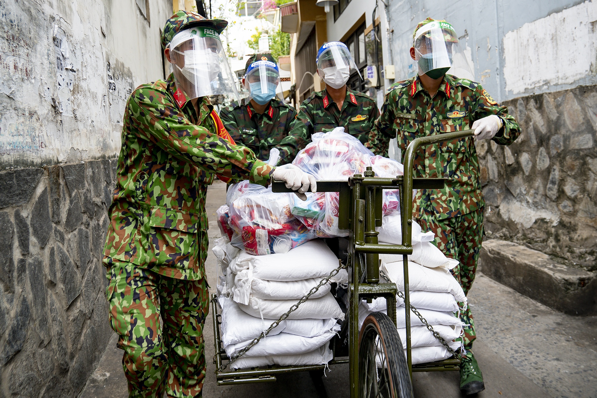 Xe dap tho chuyen luong thuc vao hem tiep te cho nguoi dan hinh anh