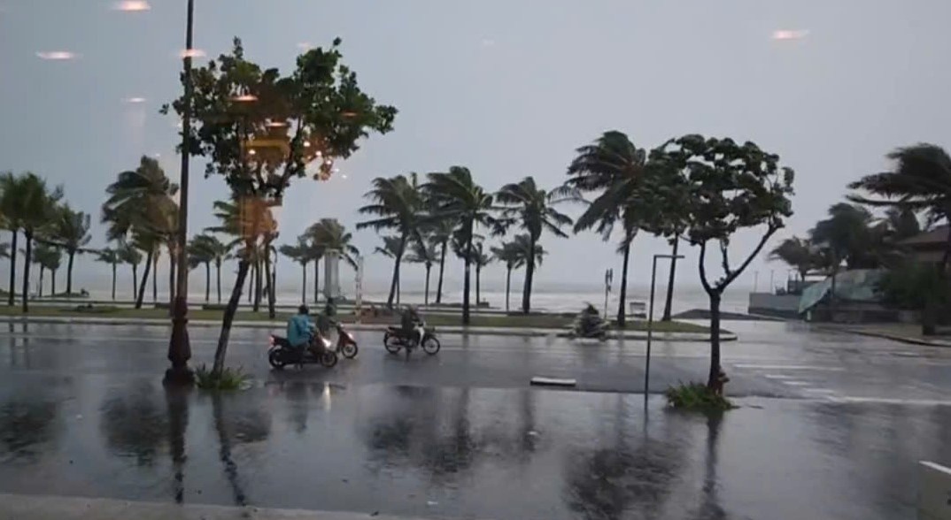 Nguoi di xe may do dam di trong gio bao giat am am ven bien Da Nang hinh anh