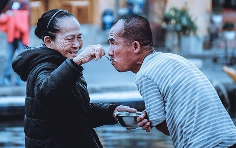 Me gia bon com cho con trai giua pho Hoi hinh anh