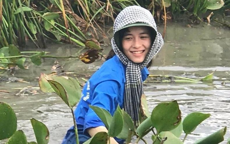 Nu sinh cuoi rang ro, ngam minh don rac duoi dam nuoc hinh anh