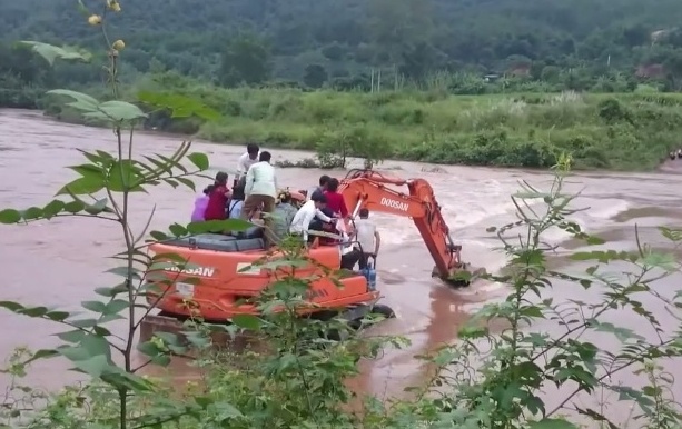 May xuc dua co dau chu re vuot dong nuoc lu hinh anh