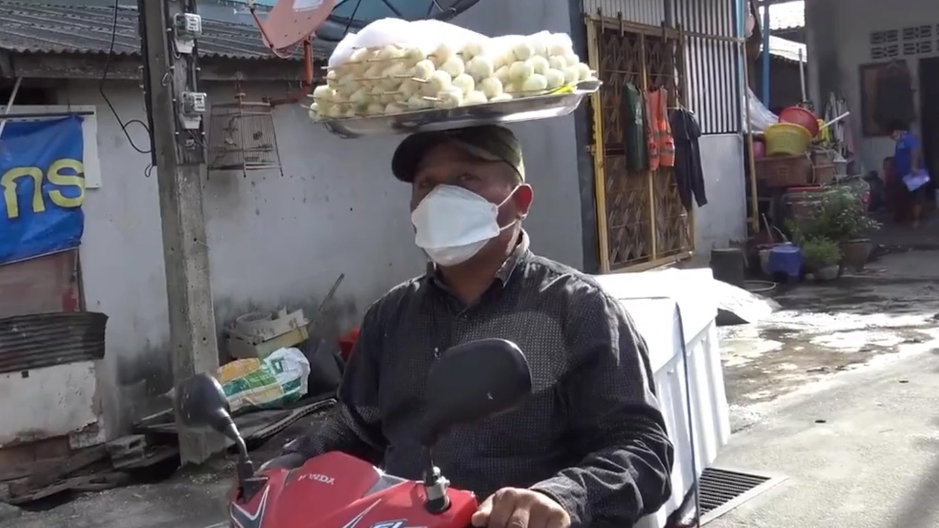 Nguoi ban hang o Thai Lan doi khay mang cut khi di xe may hinh anh