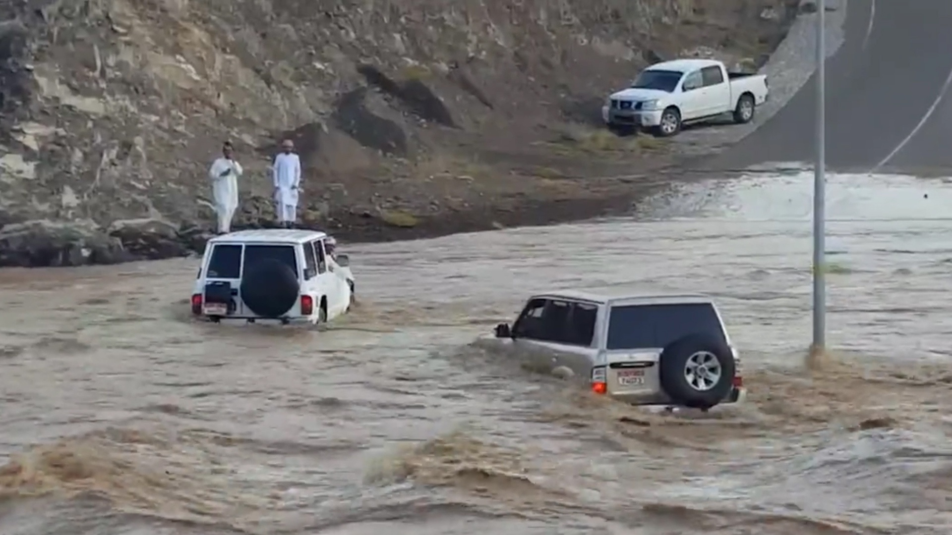 2 oto giup nhau vuot qua dong lu hinh anh