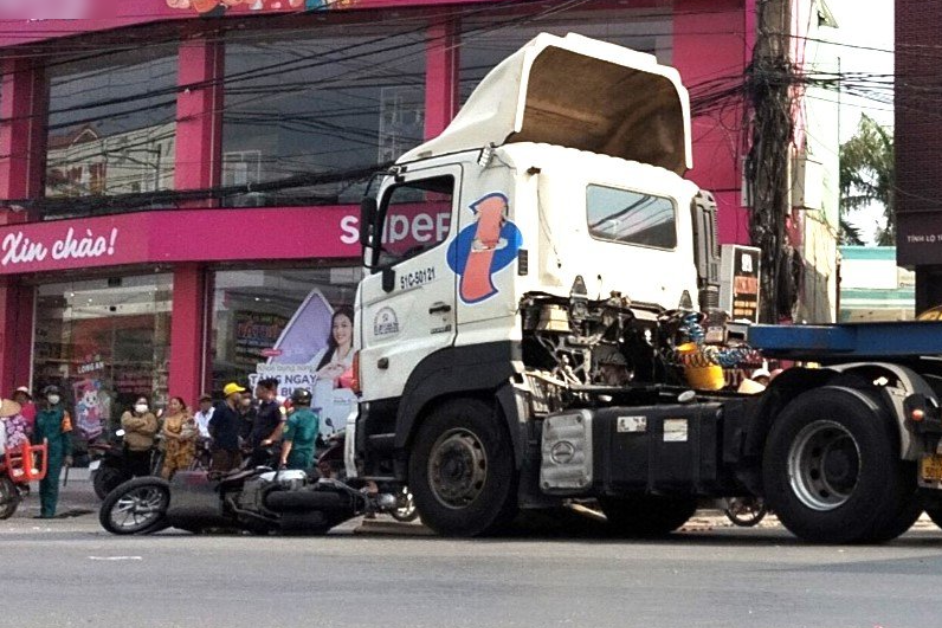 Xe container tong manh tu phia sau, nguoi phu nu lai xe may tu vong hinh anh