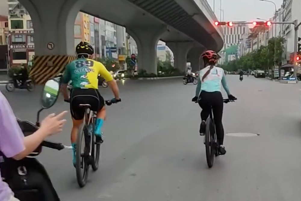 Hai nguoi di xe dap the thao ngang nhien vuot den do o Ha Noi hinh anh