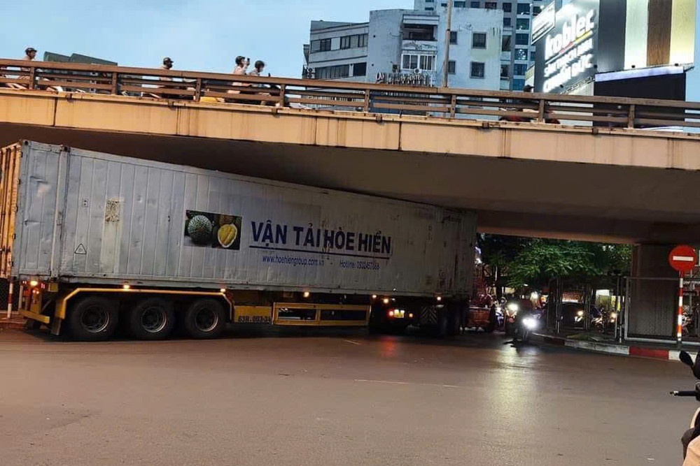 Tuoc bang lai tai xe xe container mac ket duoi gam cau Nga Tu So hinh anh