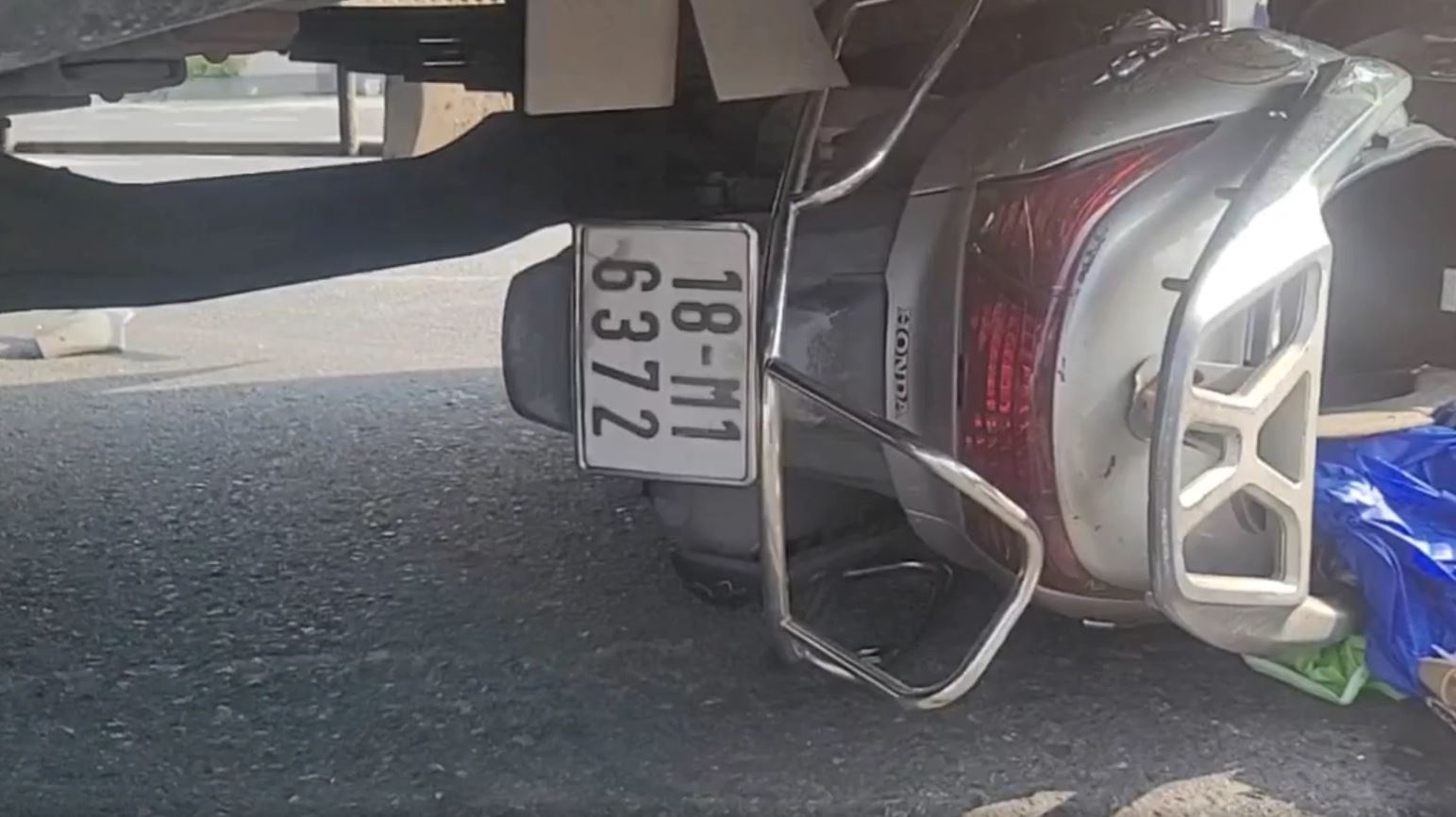 Xe may mac ket duoi dau xe tai, nguoi phu nu nam bat dong o Binh Duong hinh anh