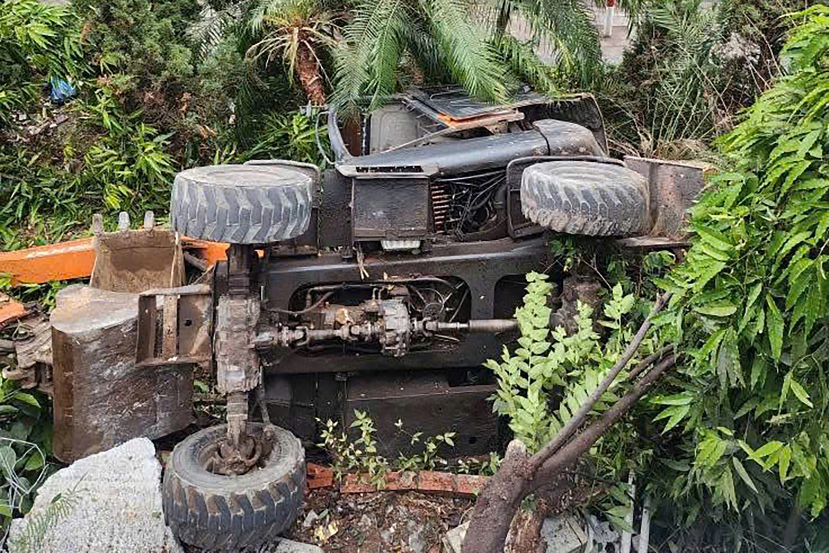 May xuc len doc thi tut lui khong phanh, lat xuong ke, mot nguoi chet hinh anh