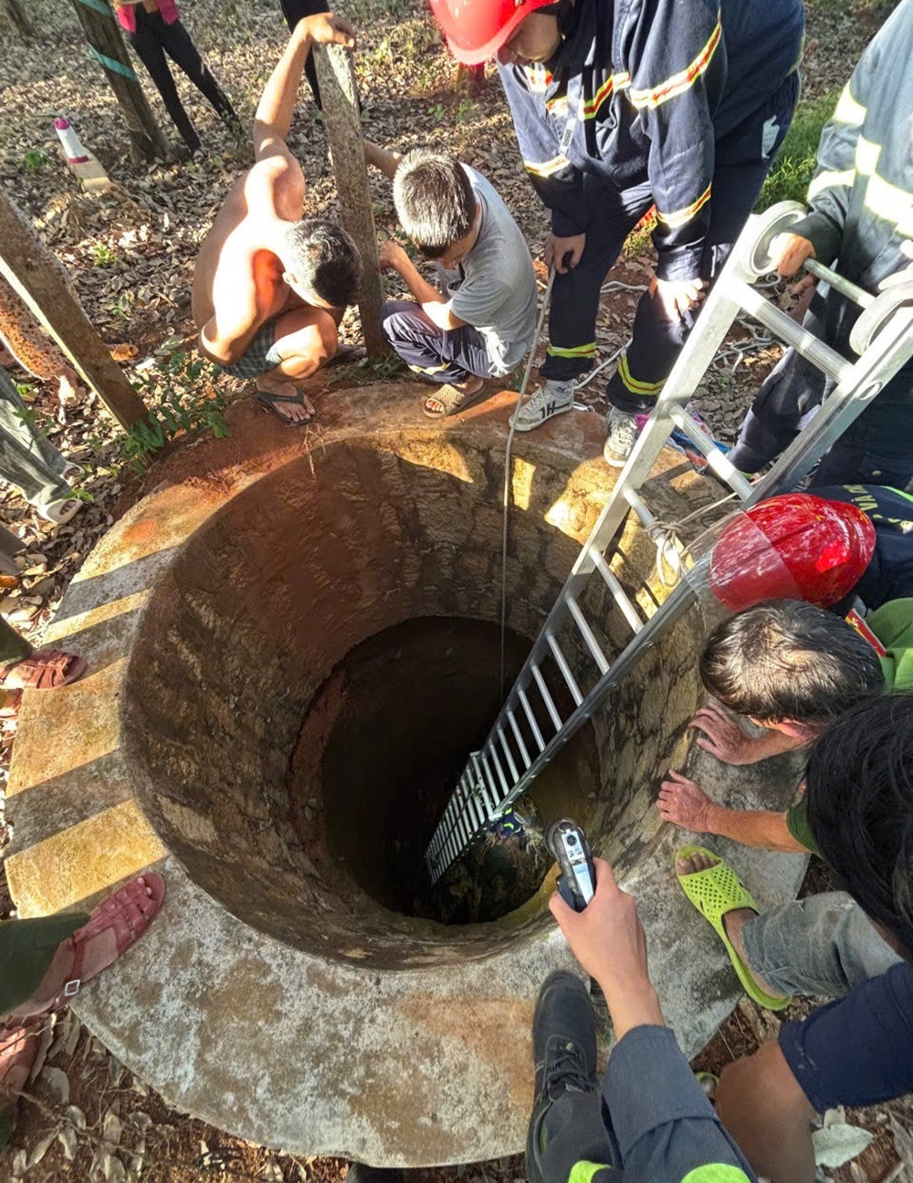 Canh sat giai cuu nguoi dan ong bi roi xuong gieng sau 10 m hinh anh