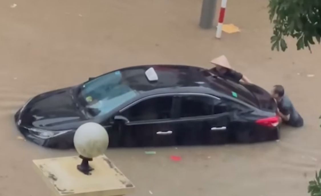 Nguoi dan bi bom day oto ngap trong bien nuoc sau mua lon hinh anh