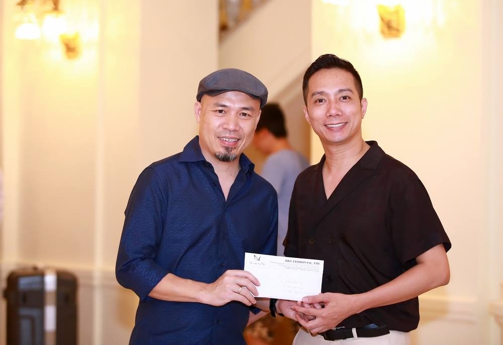 Nhạc sĩ Huy Tuấn - đại diện Ban tổ chức - nhận 10 triệu ủng hộ từ nhà thiết kế Đỗ Trịnh Hoài Nam.