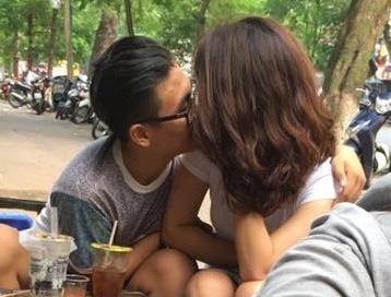 Chang trai hon, cham vao vong mot cua ban gai noi cong cong hinh anh