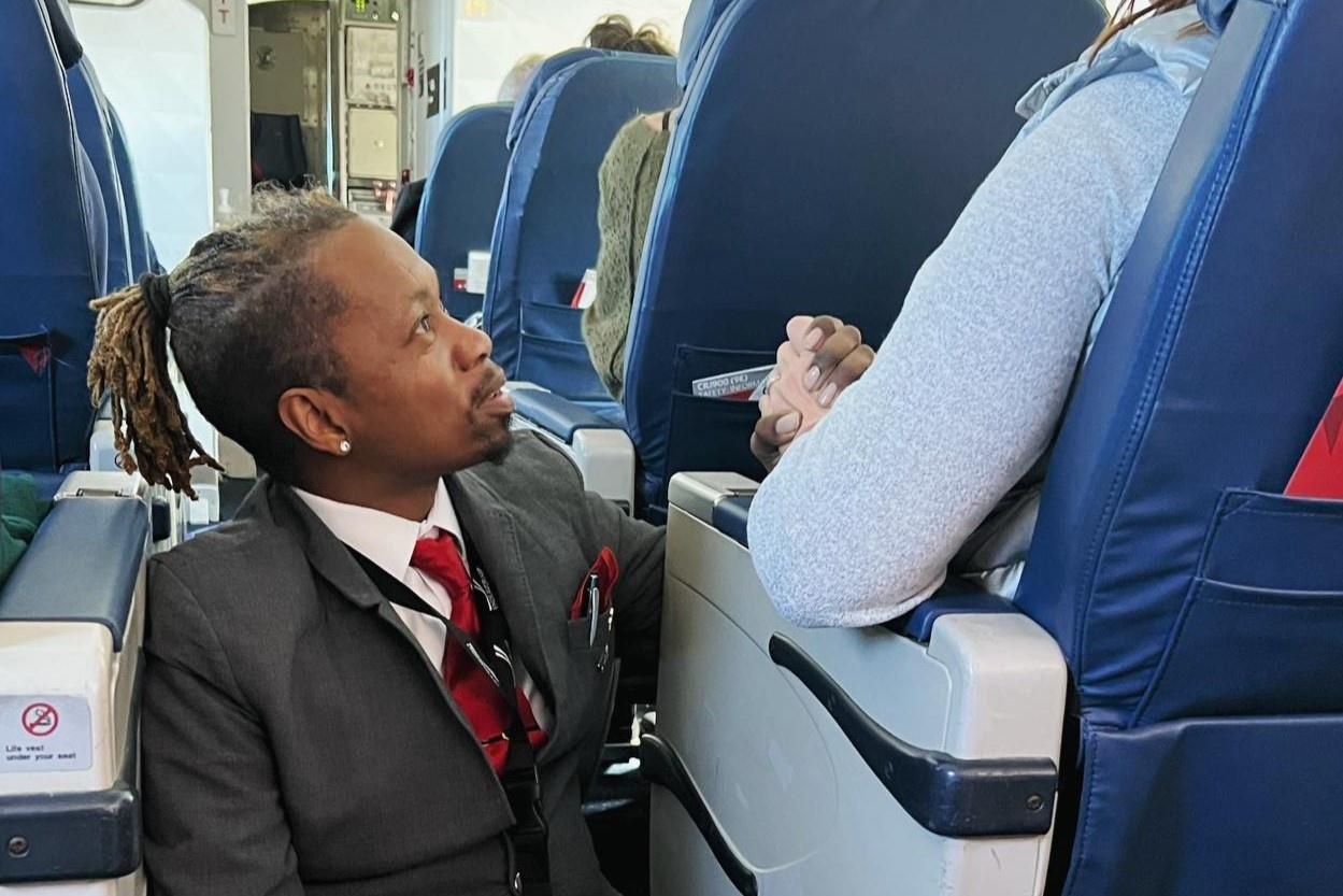 Tiep vien hang khong ngoi giua loi di, nam tay dong vien hanh khach hinh anh